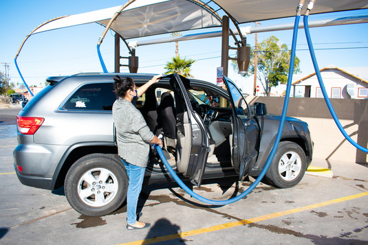 A woman at the 4th ave. location using the free vacuums to clean her SUV.